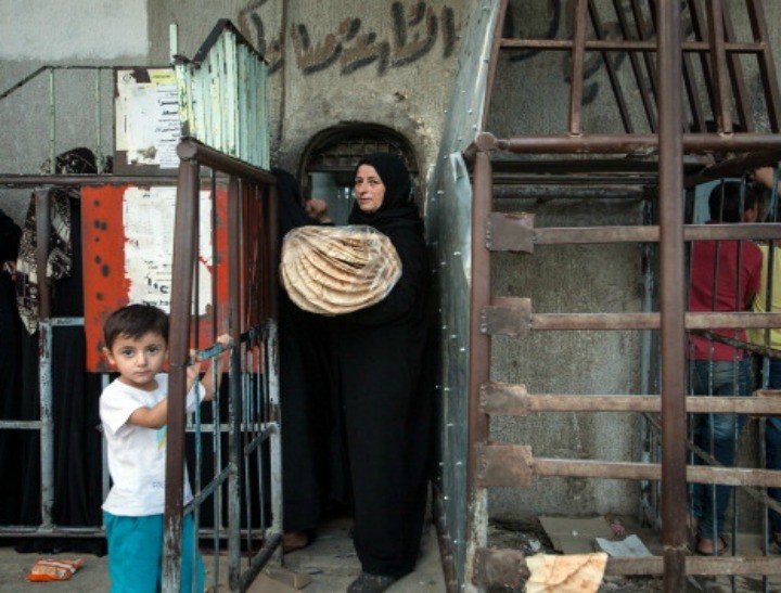 A Syrian woman carrying a bag of bread exits a bakery in Raqqa, Syria. (NB: This is not the woman to which this story refers.)