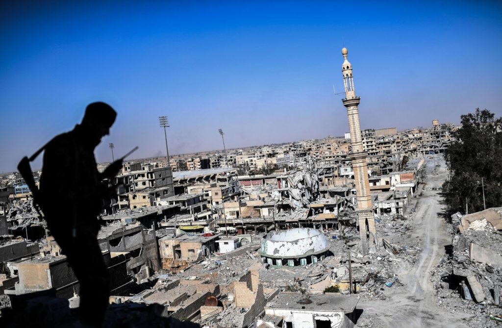 A member of the Syrian Democratic Forces, backed by U.S. special forces, talks on the radio near Raqqa's stadium as they clear the last positions on the front line on Oct. 16, 2017. The city was an important Islamic State group stronghold. Bulent Kilic/AFP/Getty Images